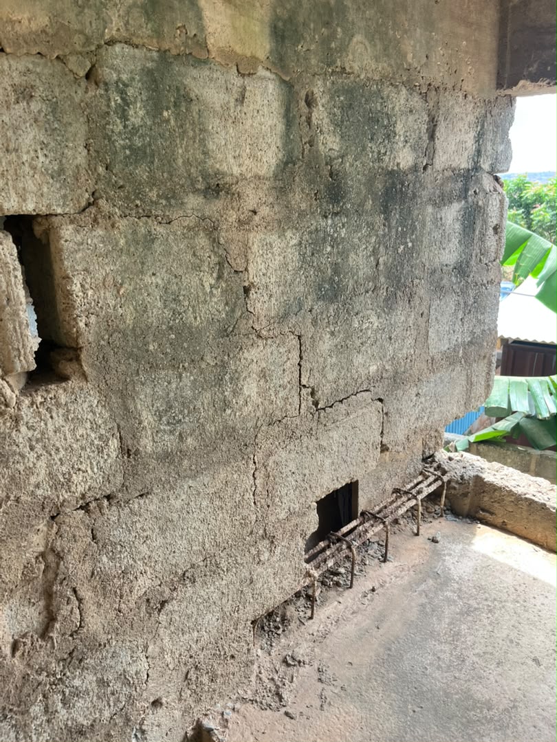 Vertical wall crack and exposed reinforcement in an Abokobi building, Ghana.
