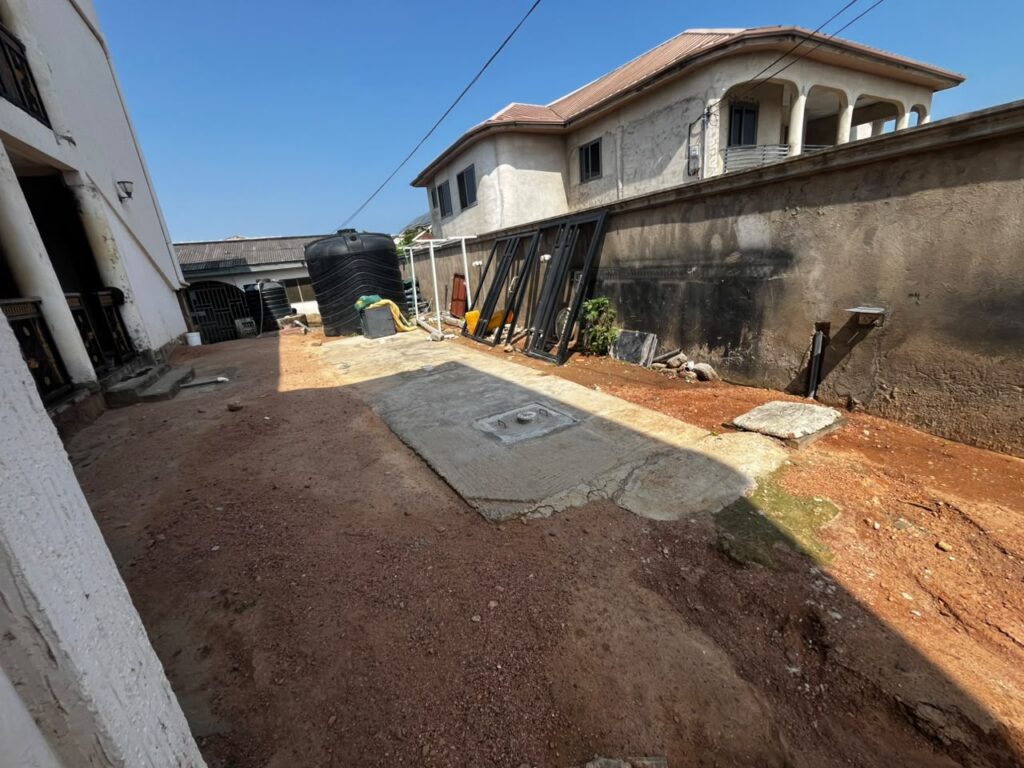 Biofil toilet system with a concrete cover slab and inspection hatch in a residential compound